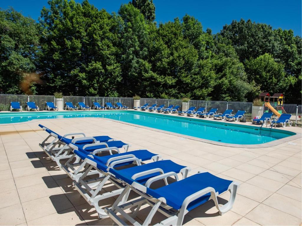 a group of blue lounge chairs by a swimming pool at Lac Bleu nr 10 in Lacapelle-Marival