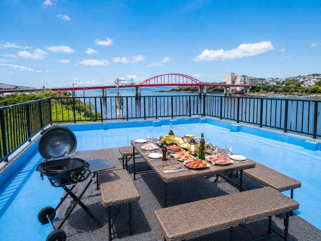 a table with food and a grill on a balcony at ゲストハウスMoana 那珂湊おさかな市場徒歩5分,9名可,BBQ可 in Hitachinaka