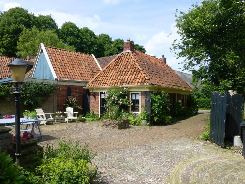 una casa con un patio de ladrillo delante de ella en Lutje Hoeske en Tinallinge