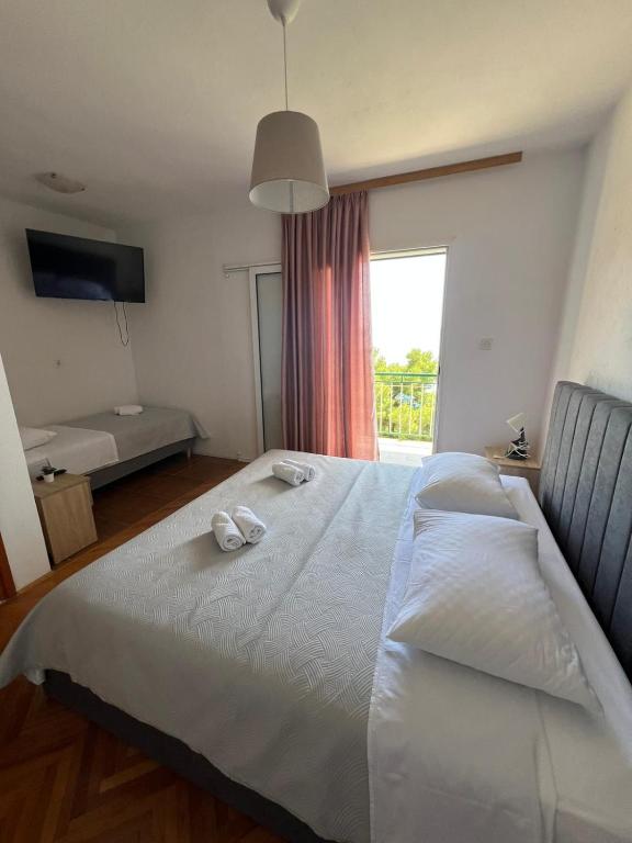 ein Schlafzimmer mit einem Bett, auf dem zwei Hausschuhe liegen in der Unterkunft Rooms with shared kitchen "Milica" in Drvenik
