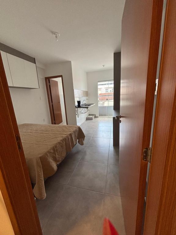 a bedroom with a bed and a door to a room at Studio in Barbacena
