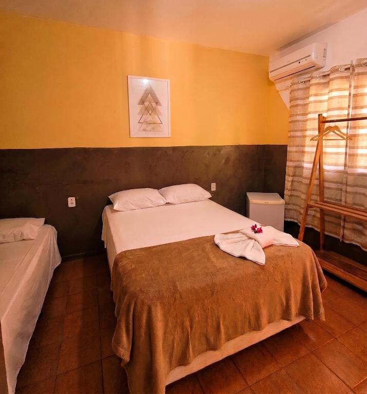 a bedroom with two beds in a room with yellow walls at Pousada SolMaris in João Pessoa
