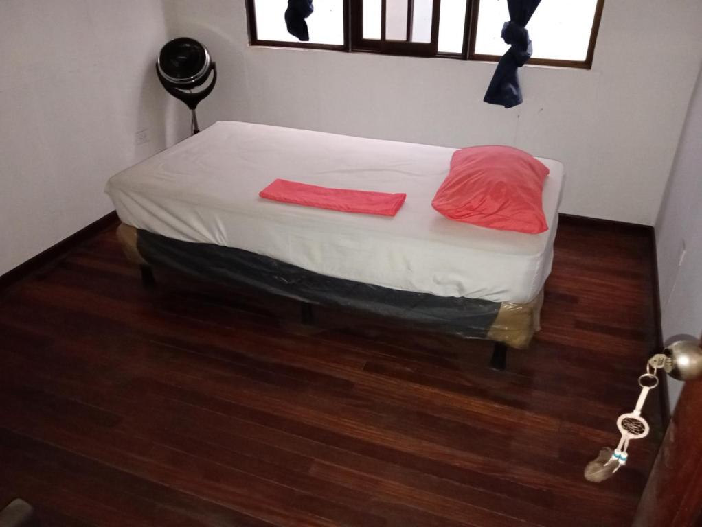 a bed with two red pillows on it in a room at El Cacique in Alajuela