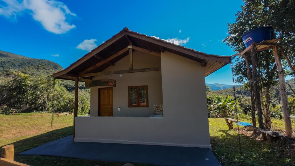a small white house with a roof at Chalé Morada das estrelas in Aiuruoca