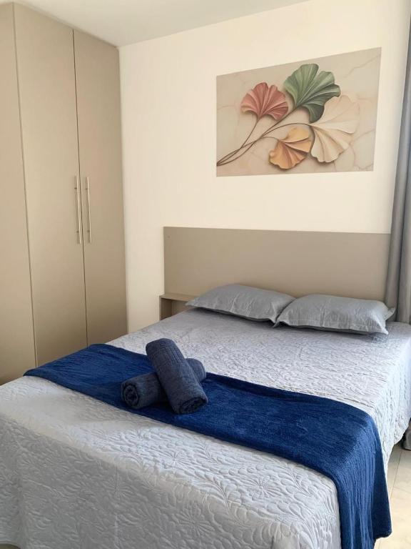 a bedroom with a bed with two blue towels on it at Studio moderno com cozinha completa e Wi-Fi centro in Barbacena