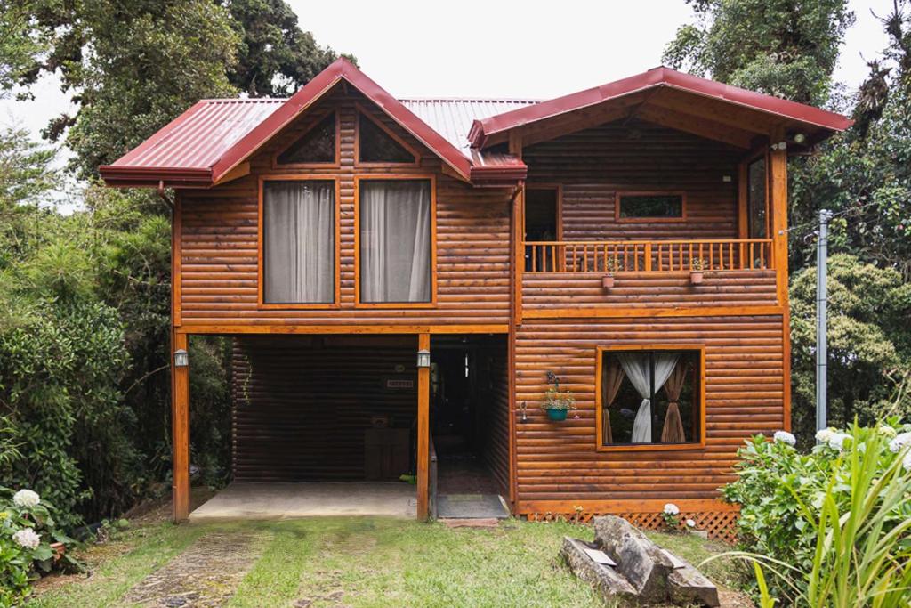 a wooden house with a garage in front of it at Cabaña Facovi in Empalme