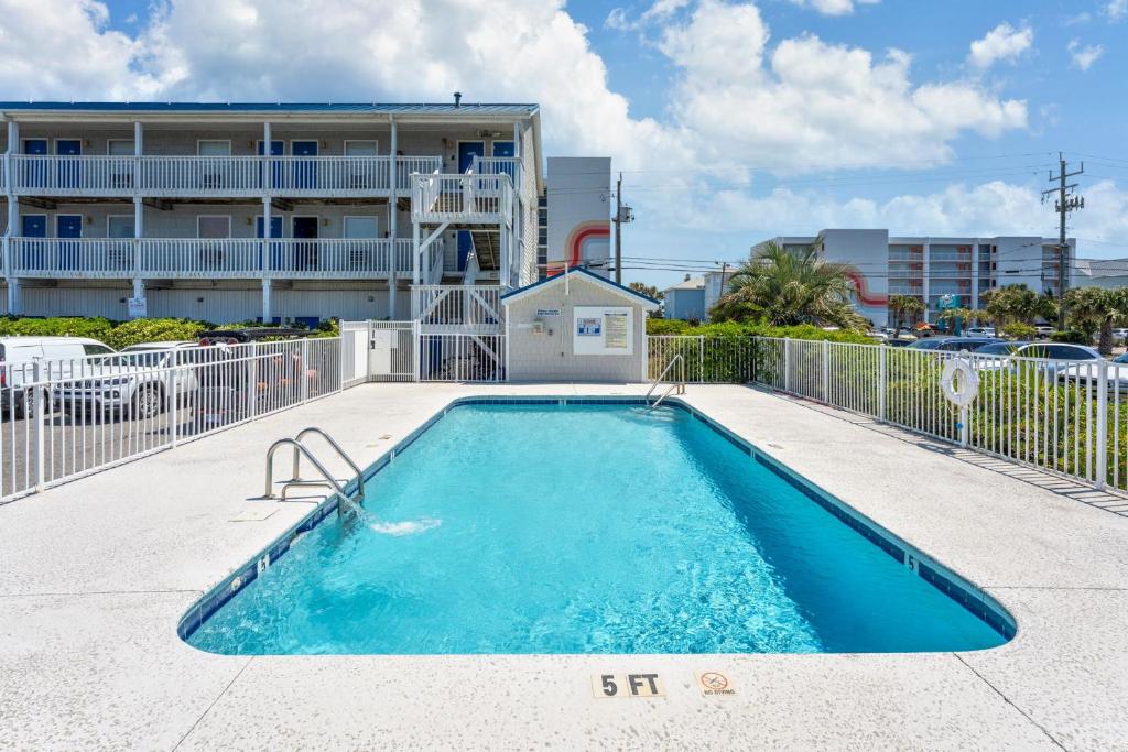 a swimming pool in front of a building at Co Sea Casa in Carolina Beach
