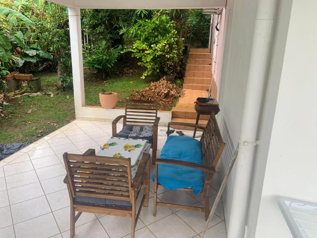 eine Terrasse mit zwei Stühlen und einem Tisch mit einem blauen Kissen in der Unterkunft Lechampfleury in Garnier