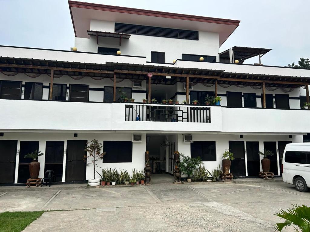 a white building with a white van parked in front of it at Anabelle Residence in Dumaguete