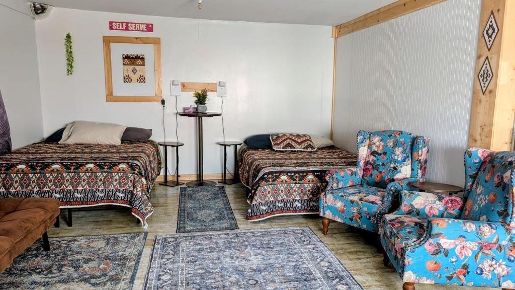 a living room with a couch and a bed and a chair at Geraldton Rooms in Geraldton