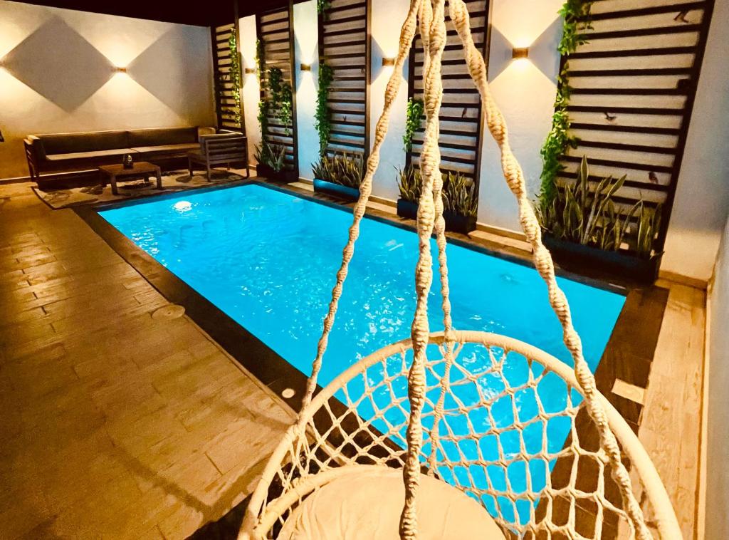 a swing in front of a swimming pool at Casa Luque in Culiacán