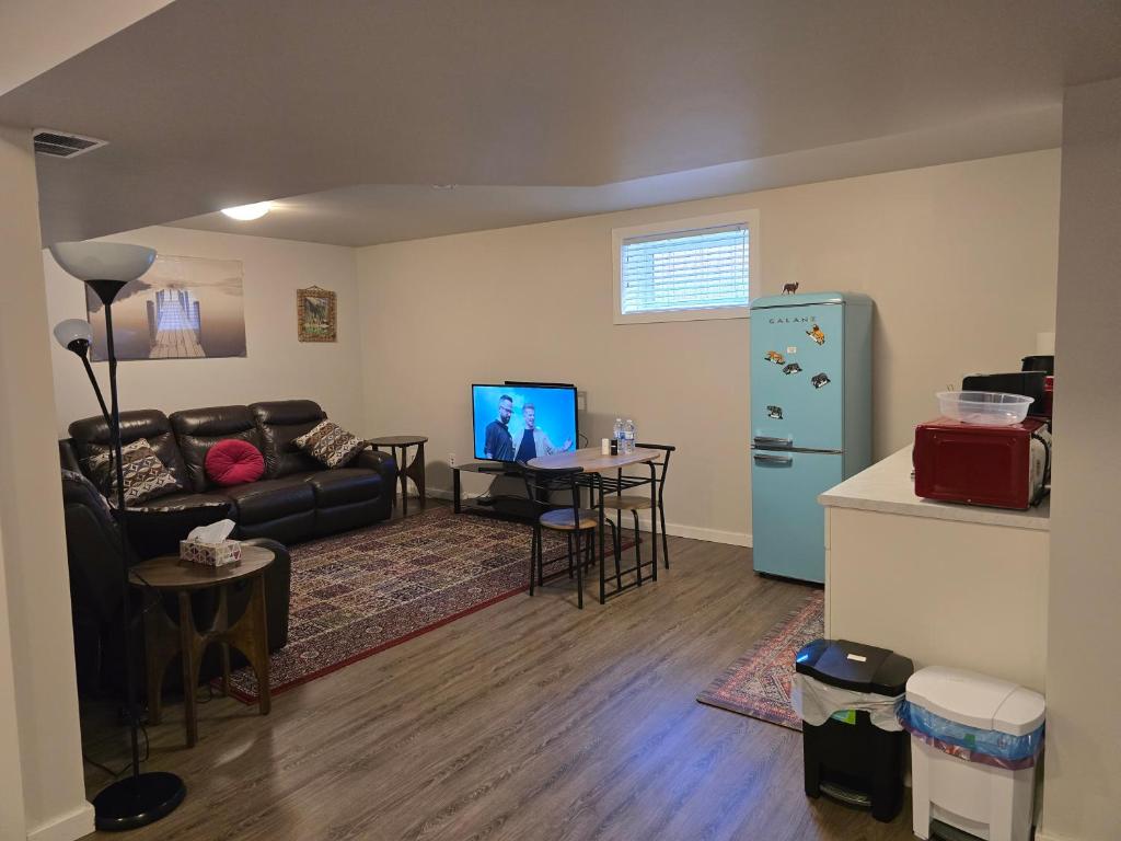 a living room with a couch and a table and a refrigerator at The Peaceful Lower Loft in Winnipeg