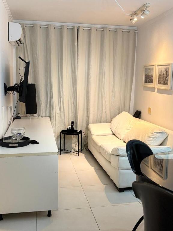 a living room with a white couch and a desk at Apartamento com 02 quartos in Maceió