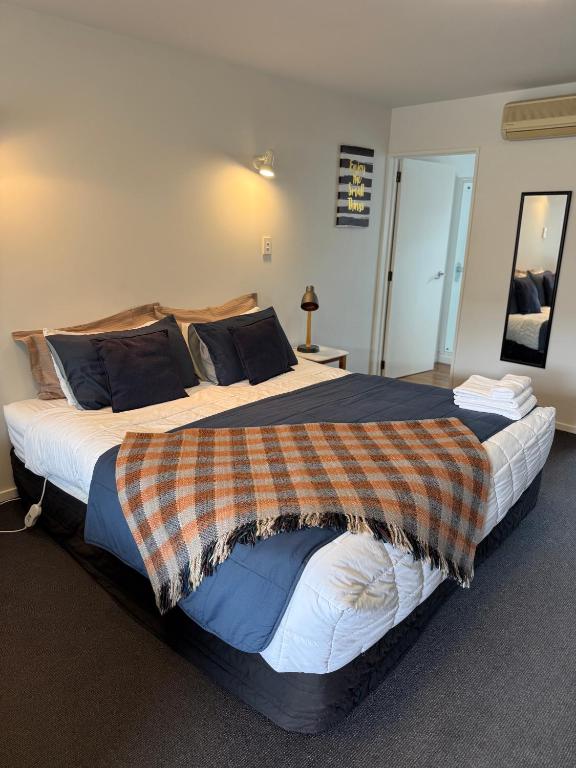 a bedroom with a large bed with a blanket on it at #5 Glenorchy Alpine Suite in Glenorchy