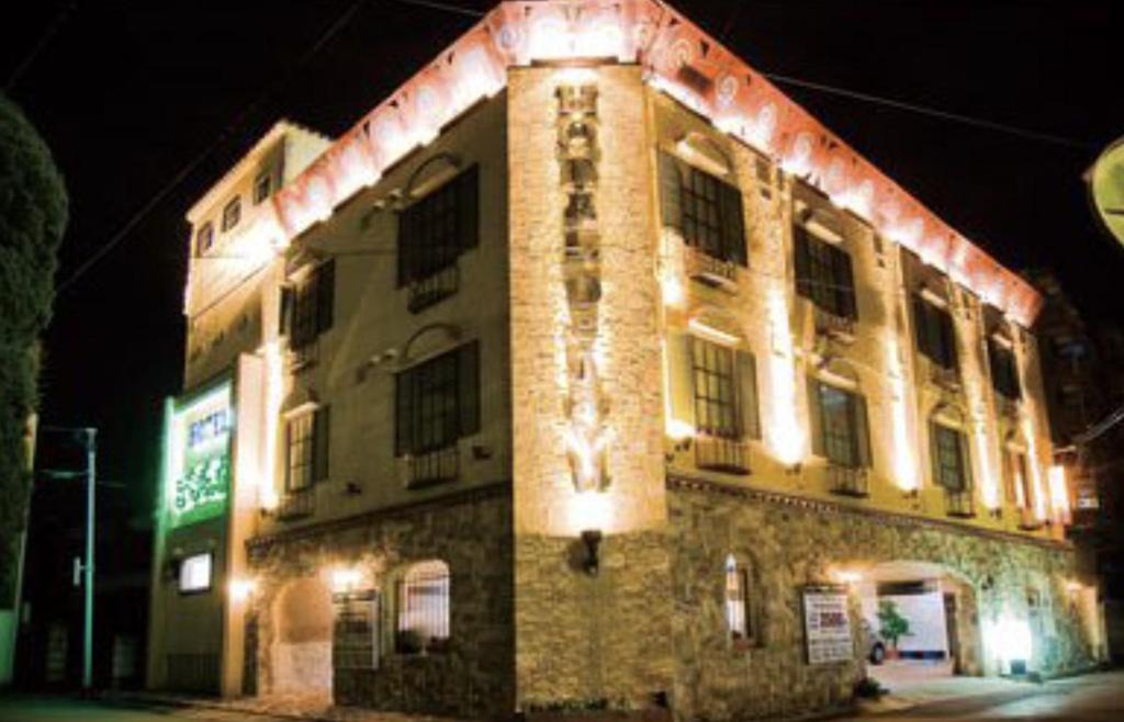 a building with lights on the side of it at night at ホテルデジャブ大人専用 in Akita