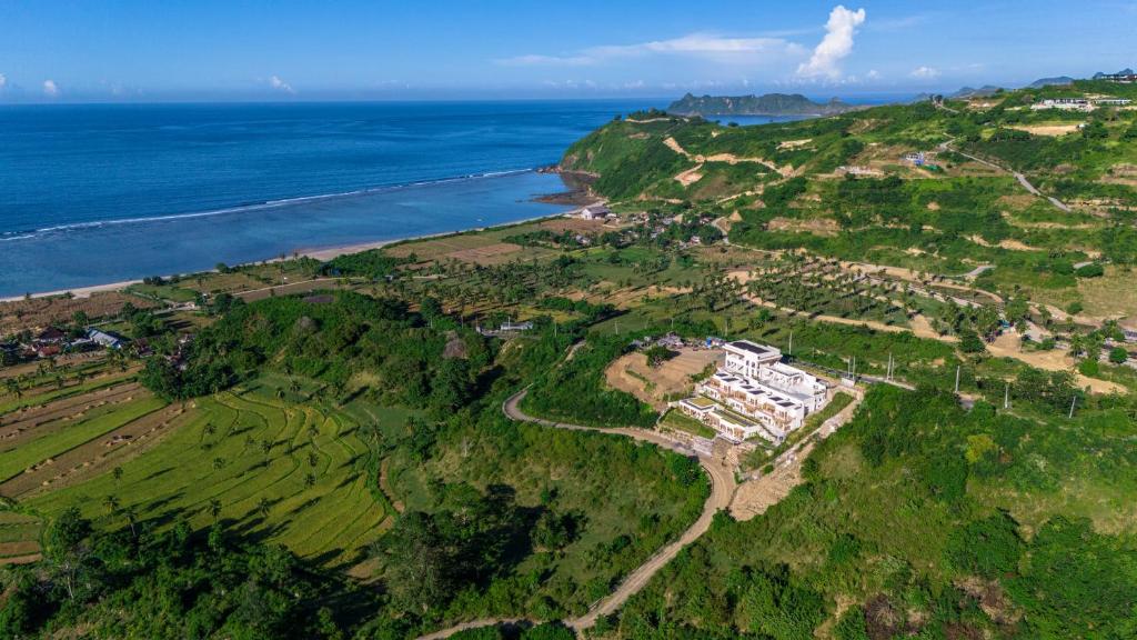 an aerial view of a house on a hill next to the ocean at Sereno Lombok Resort in Selong Belanak