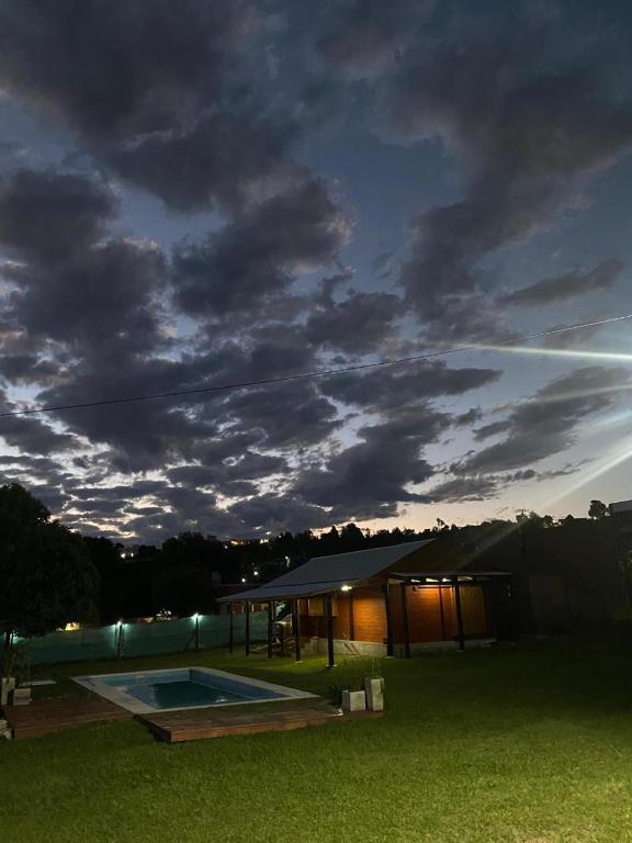 a night view of a building with a swimming pool at Cabañas del Valle in Huerta Grande