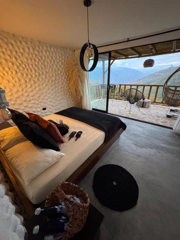 a bed in a room with a view of the desert at Mambe refugio in Piedecuesta