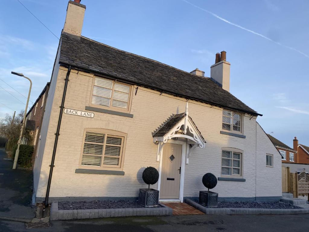 a white building with a white door on a street at No2 Back Lane in Thrussington