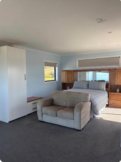 a bedroom with a bed and a couch and a chair at Bluff View in Ocean Beach
