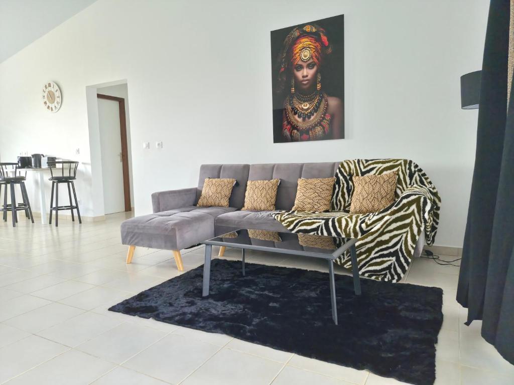 a living room with a couch and a painting on the wall at Bella - Destination Guyane in Rémire-Camp