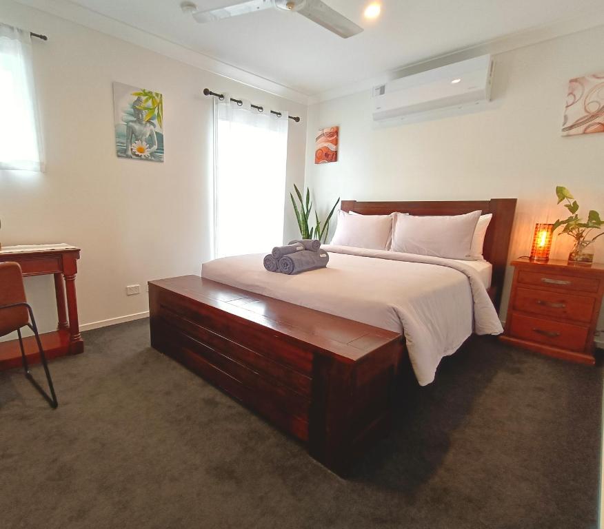 a bedroom with a bed with a dresser and a window at Deluxe Queen Room - Shared Bathroom in Holmview