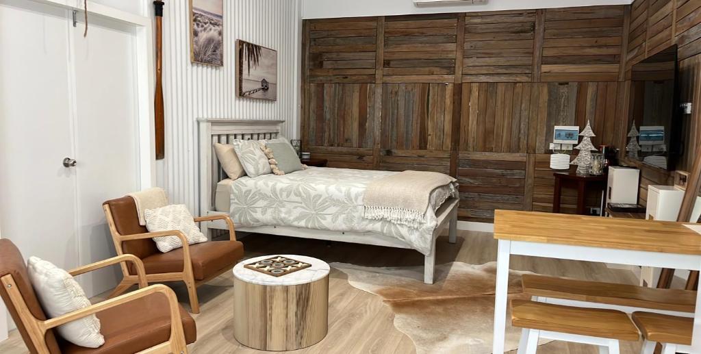 a bedroom with a bed and a table and chairs at South West Rocks Gap Beach Studio in Arakoon