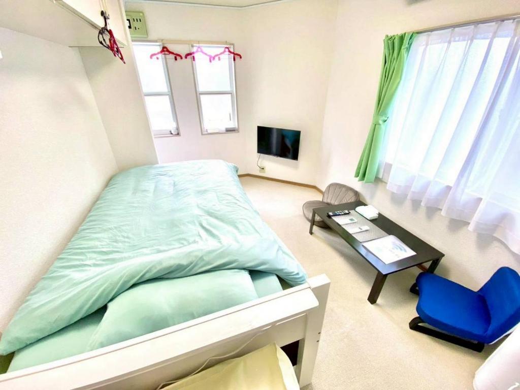 a bedroom with a bed and a desk and a tv at トリトン茶屋町#101#102 in Aomori