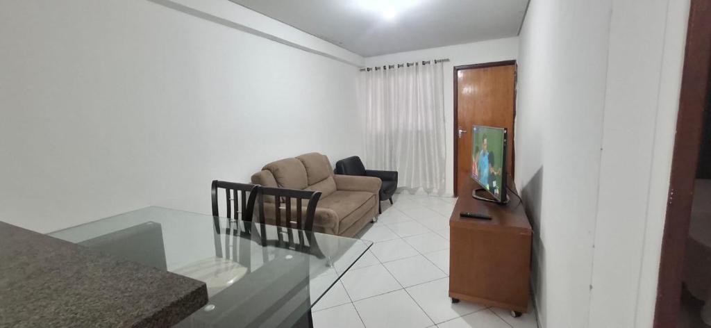 a living room with a couch and a tv at Casa 3 quartos - mês com ofertas in Campo Grande