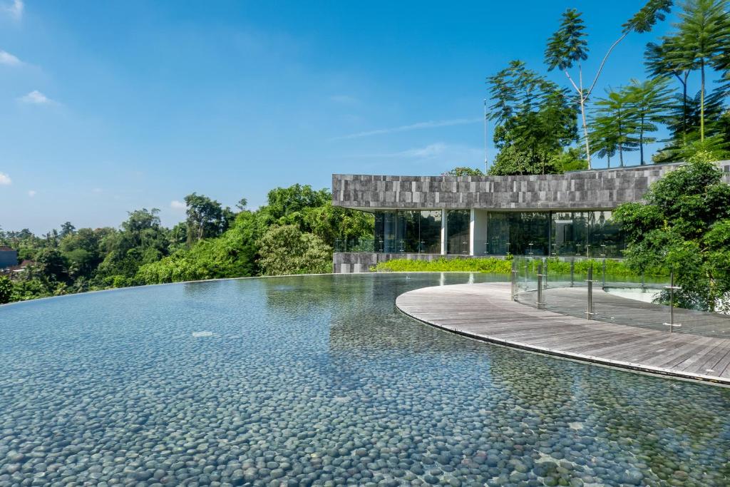 a pool of water with a building in the background at Bumi Kinar Skylight in Ubud
