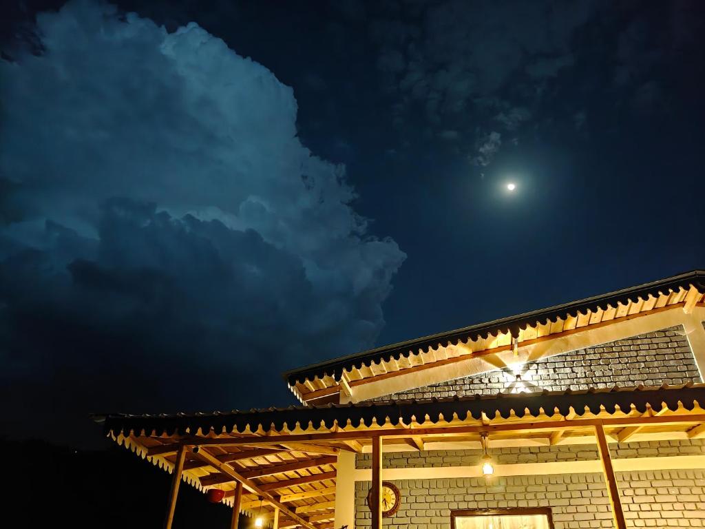 a building with the moon in the sky at Ekatma Stays - Farm & Homestay, Kakrighat in Shitlakhet