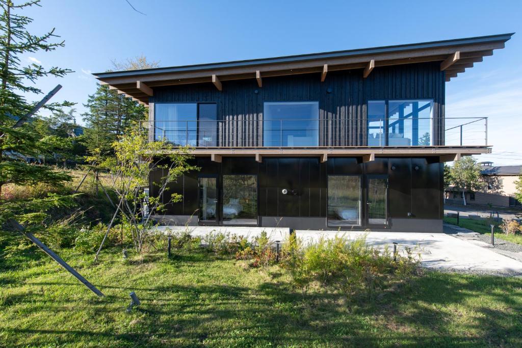 a house with large windows and a yard at Shiyuki in Furano