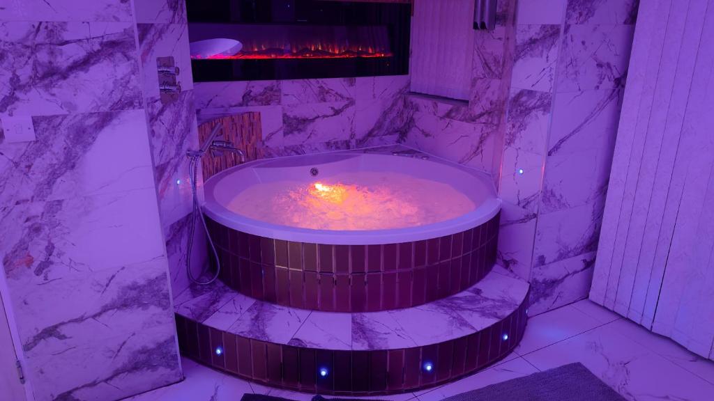 a hot tub in a room with a fireplace at Azura Suites in Bradford