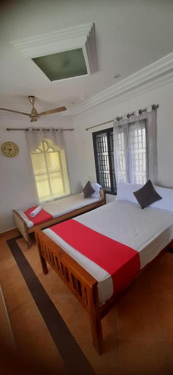 a bedroom with two beds and two windows at De Lemo 3BHK Villa Homestay in Pondicherry
