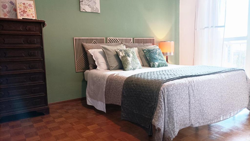 a bedroom with a bed with pillows and a dresser at QuickHome Appartamento Rovere in Biella