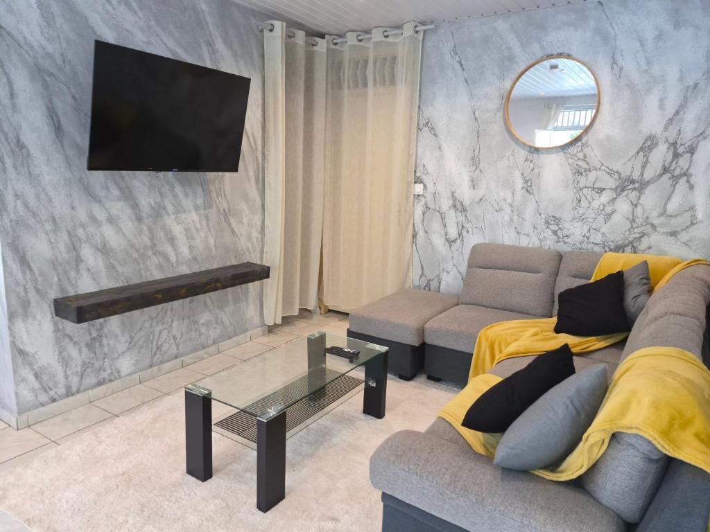 a living room with a couch and a tv at Oya - Destination Guyane in Macouria