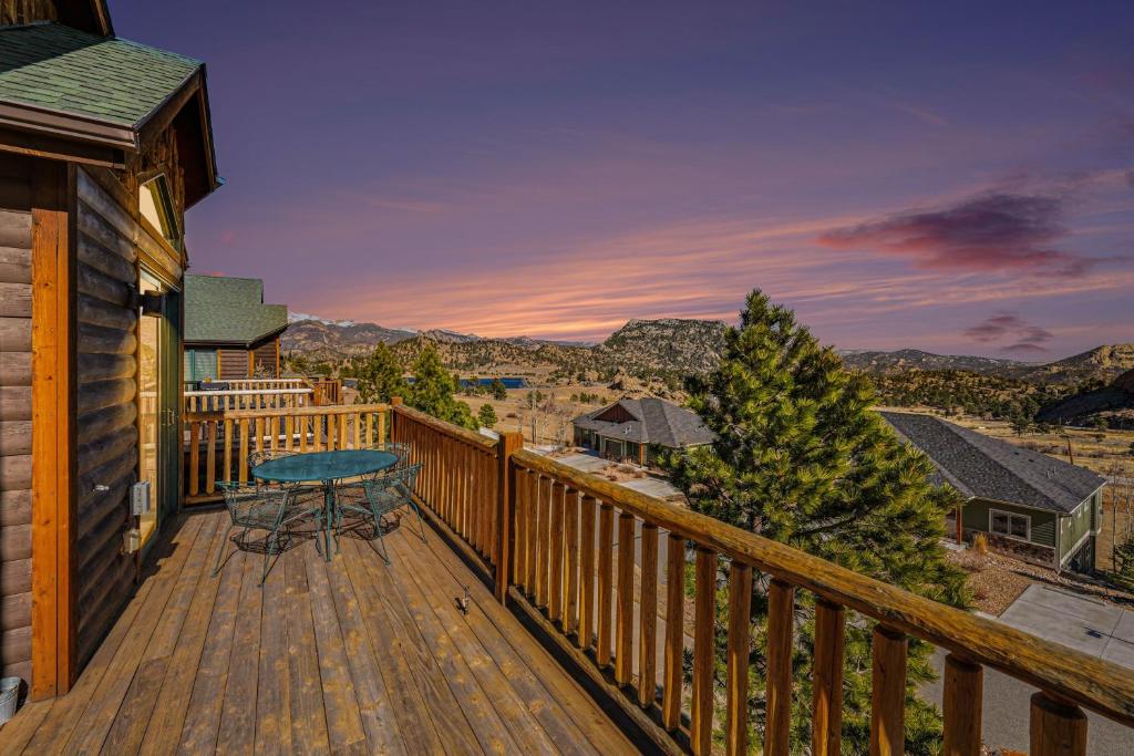 a deck with a table and a view of the mountains at Teepee Mountain 12A Condo in Estes Park