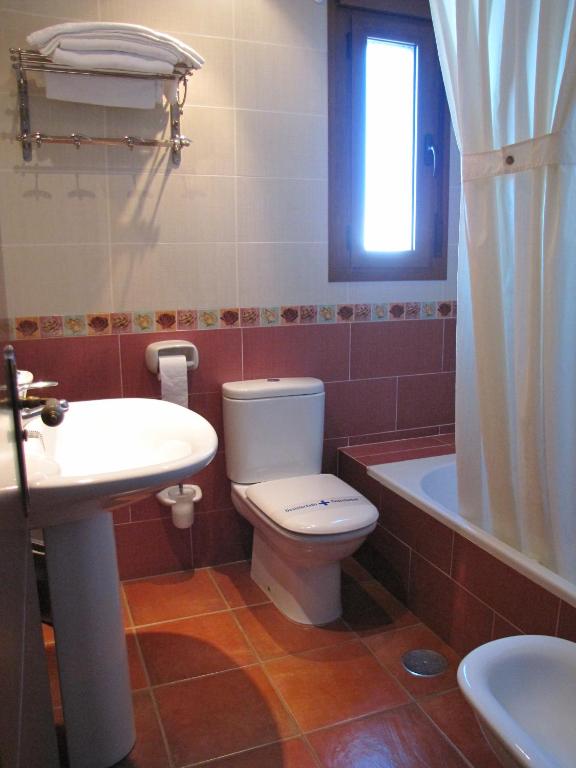 a bathroom with a toilet and a sink and a tub at Hotel-Apartamento Carolina y Vanessa in San José