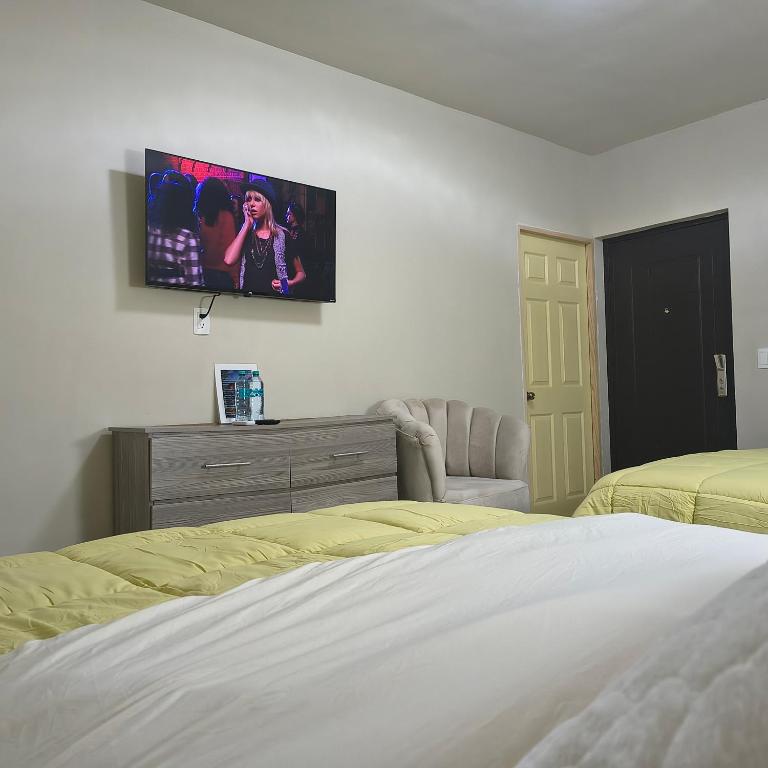 ein Schlafzimmer mit zwei Betten und einem Fernseher an der Wand in der Unterkunft Mukí Galá in Creel