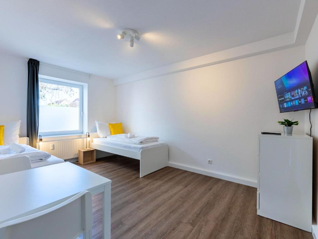 a living room with white furniture and a flat screen tv at BudgetRoom 3 BR perfect for Teams in Castrop-Rauxel