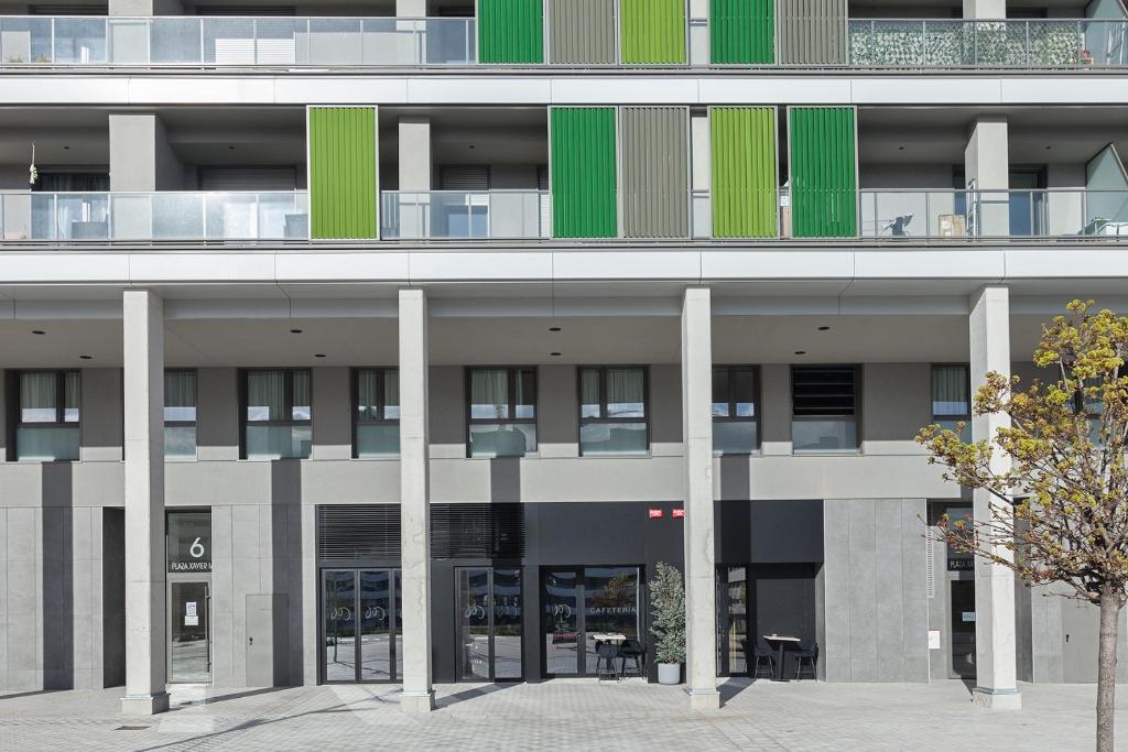 an external view of a building with green windows at Hotel Arrosadía Iriguibel in Pamplona