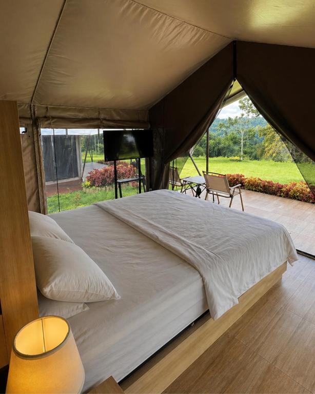 a large bed in a tent with a view at Tikumbar Glamping Pelaga in Plaga