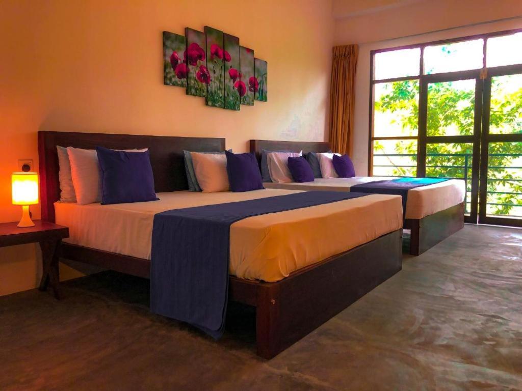 a bedroom with two beds with blue and orange at Red letter hotel in Kandy