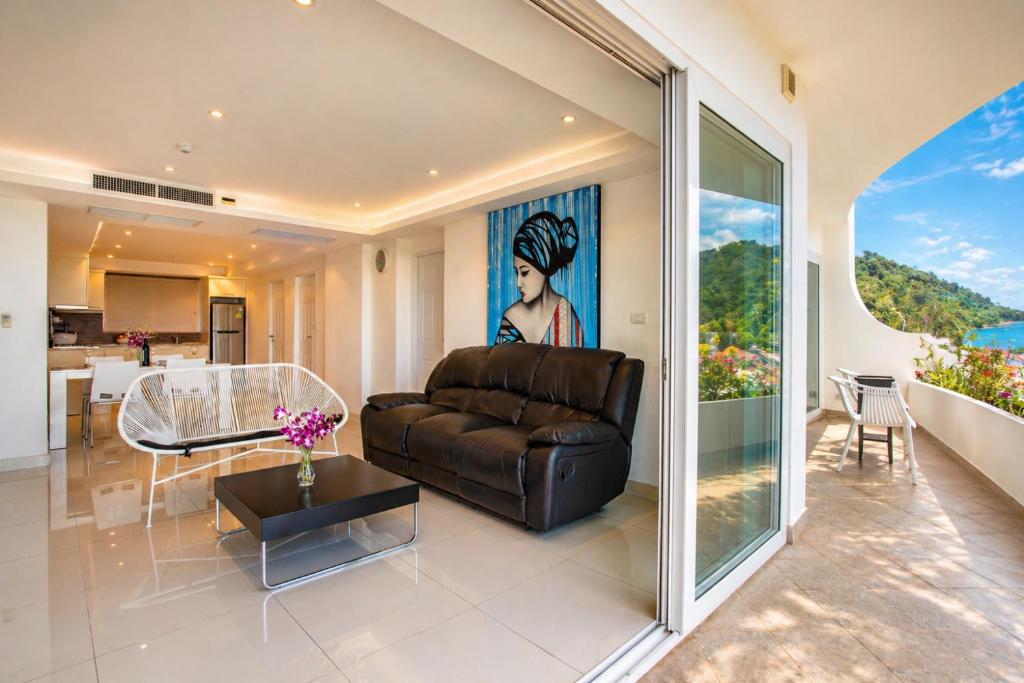 a living room with a leather couch and a table at Kata Hills Condo with Terrace & Sea View O910 in Ka Rorn