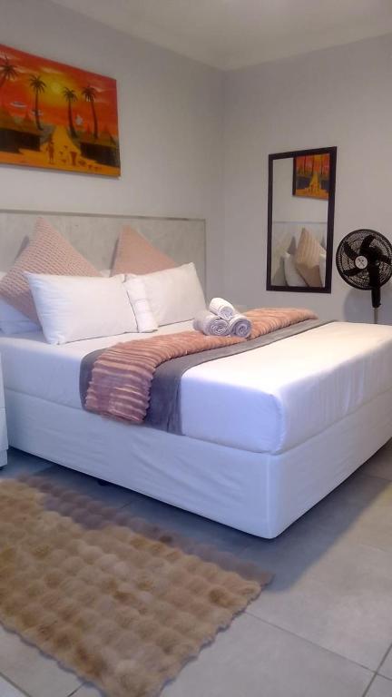 a large white bed sitting in a room at Chirute guest lodge in Randfontein