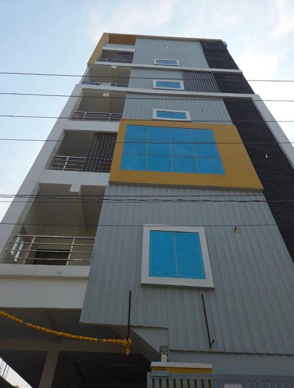 a tall building with blue windows on it at Prime PG - Coliving Hostel in Hyderabad