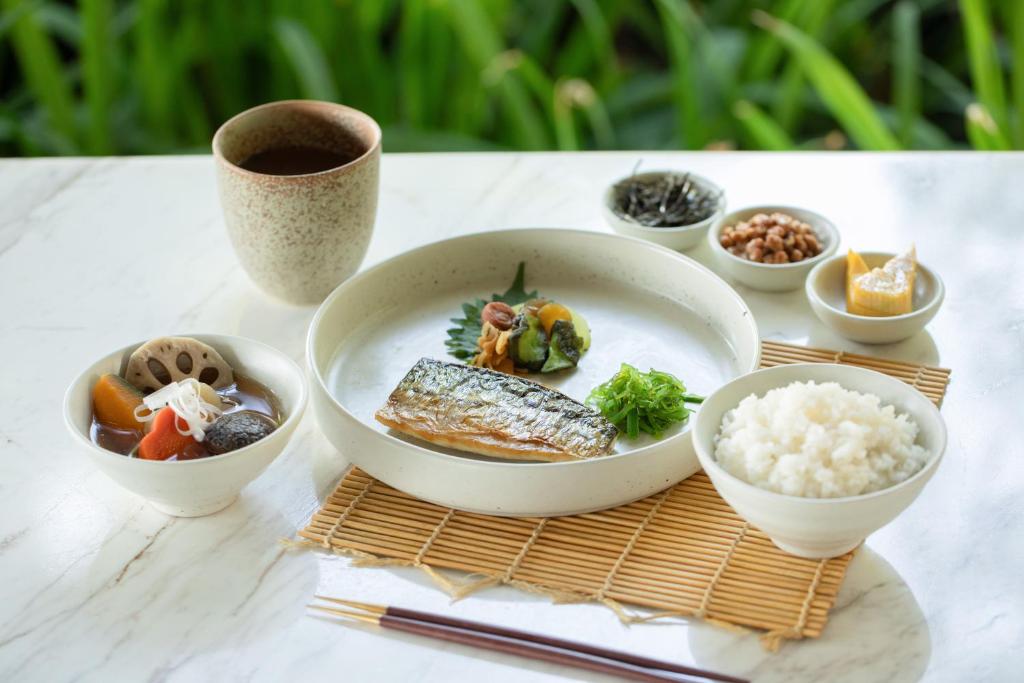 A Japanese-style meal is arranged with grilled fish, rice, soup and small accompaniments.
