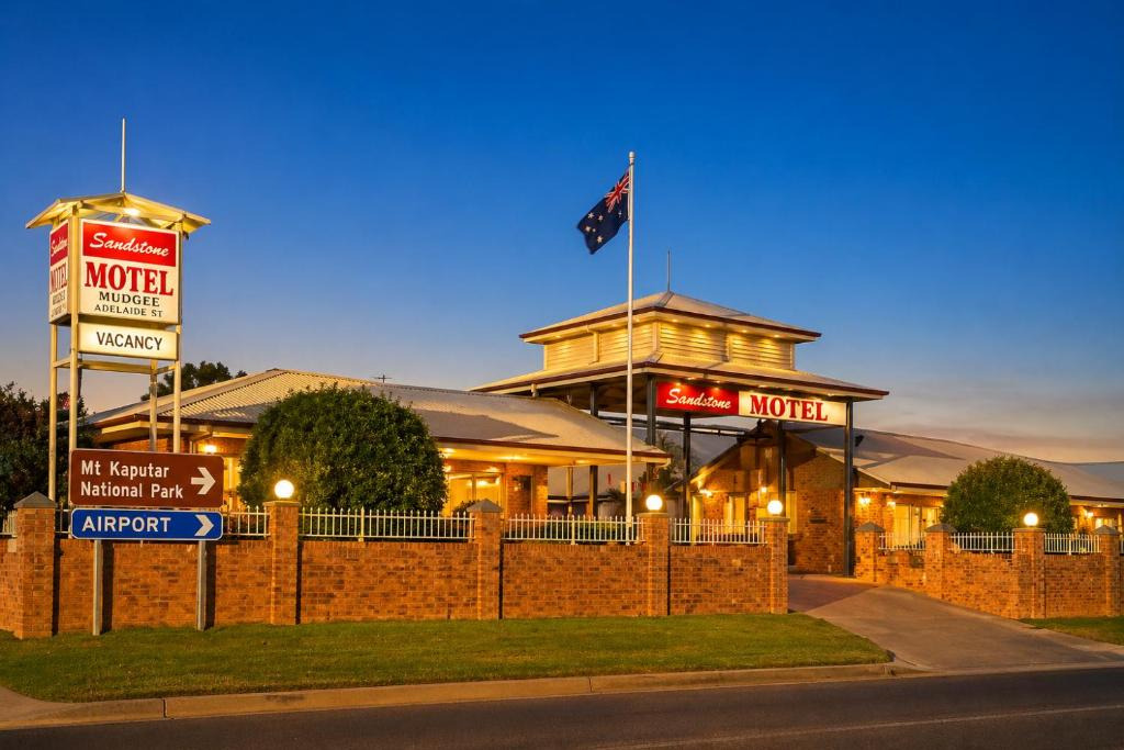 a hotel with a flag on top of a building at Southern Cross Motor Inn in Narrabri
