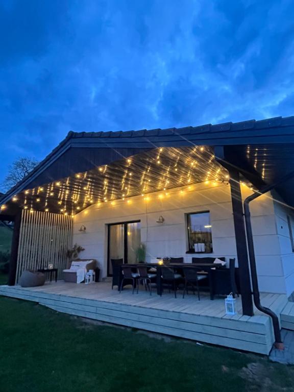 eine Terrasse mit einem Tisch und Lichtern in der Unterkunft Vila Trakai in Trakai