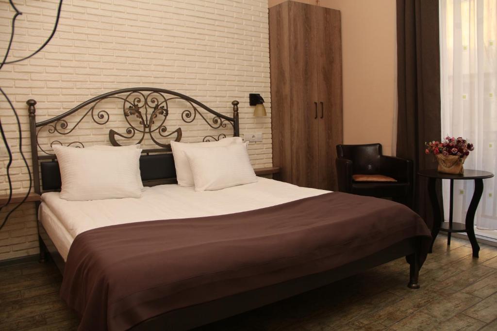 1 dormitorio con 1 cama grande y 1 silla en Hotel Delisi en Tiflis